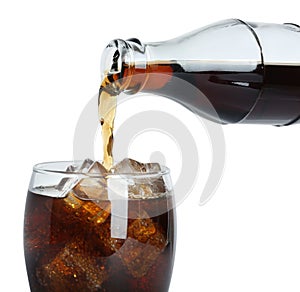 Pouring cola from bottle into glass with ice cubes on white background, closeup. Refreshing soda water