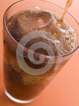 Pouring a Cola into a Glass with Ice Cubes