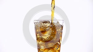 Pouring cola into a glass with the ice cubes.