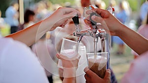 Pouring of cold drinks into a plastic glass. Bartender pouring craft beer in the bar. The hand of a man pour from keg a