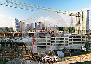 Pouring concrete from cement mixer. Tower crane on formwork at construction site. Reinforced concreting. Falsework, â€‹Frames and