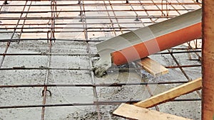 Pouring concrete mixture to the reinforcing mesh and a house foundation. Clip. Pouring liquid cement at a construction