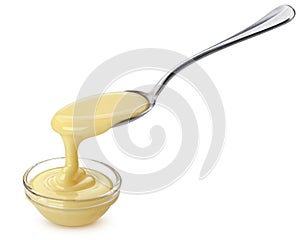 Pouring condensed milk isolated on white background