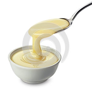 Pouring condensed milk isolated on white background