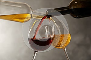 Pouring different wines from bottles into glasses photo