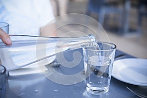 Pouring Distilled water into a clear glass at a restaurant