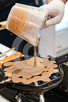 Pouring a dough. Preparing Hong Kong waffles in kitchen