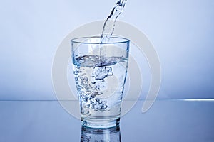 Pouring drink mineral water into a glass
