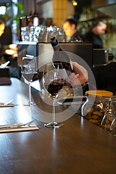 Pouring of dry Spanish tempranillo red wine in glass in Spanish bogeda restaurant photo