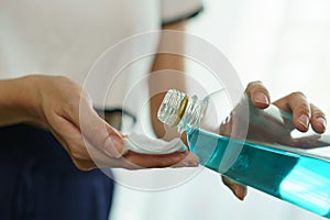 Pouring ethyl alcohol from bottle  into a cotton piece for corona virus or Covid-19 protection