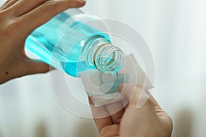 Pouring ethyl alcohol from bottle  into a cotton piece for corona virus or Covid-19 protection photo