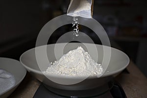 Pouring flour into a deep plate. Low light