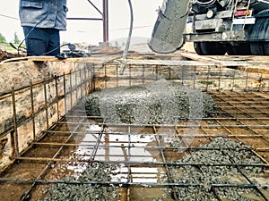 Pouring the foundation with concrete at the construction site. Monolithic reinforced concrete works during the construction of the