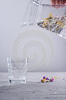 Pouring fresh clean water from a glass jug.