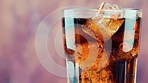 Pouring fresh coke with ice cubes isolated on wood background