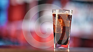 Pouring fresh cola beverage in transparent glass with ice piece. Shot on RED Raven 4k Cinema Camera