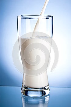 Pouring a Fresh Glass of Milk on a blue