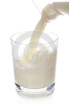 Pouring fresh glass of milk isolated