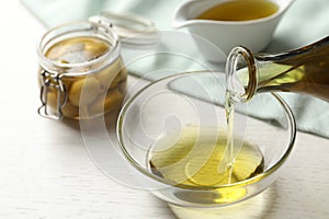 Pouring fresh olive oil into bowl