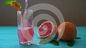 Pouring fresh ruby grapefruit juice
