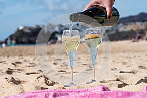 Pouring a glass of champagne on vacation, south of Fuerteventura, Canary islands, blue ocean, mountains