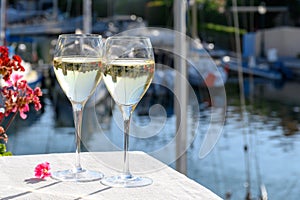 Pouring in glass of cold white Cote de Provence wine in yacht harbour of Port Grimaud, summer vacation on French Riviera in