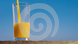 Pouring a glass of orange juice creating splash