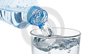 Pouring glass of water from a plastic bottle isolated