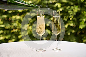 Pouring a glass of white sparkling wine or champagne