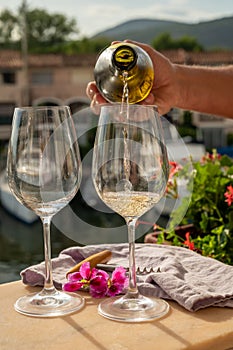 Pouring in glasses of cold white wine in yacht harbour of Port Grimaud, summer vacation on French Riviera, France