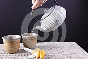 Pouring green tea and serving fortune cookies