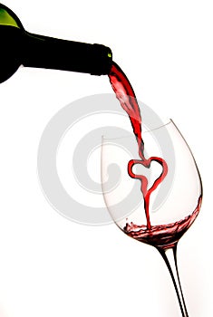 Pouring a heart of red wine into a glass