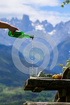 Pouring from high height of natural Asturian made from apples, Asturian cabrales cow blue cheese with view on