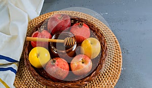 Pouring honey on apple and pomegranate with honey symbols of Jewish New Year - Rosh Hashanah