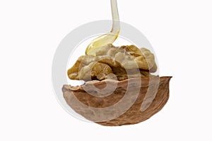 pouring honey on a floating walnut, isolated on white