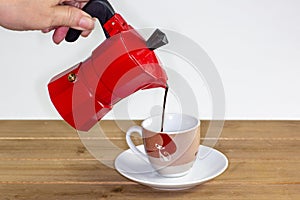Pouring a hot expresso coffee into a glass