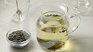 Pouring hot water in a glass teapot to make green gunpowder tea