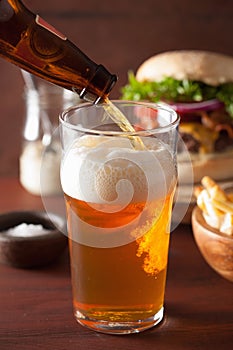 Pouring india pale ale beer into pint glass and fastfood