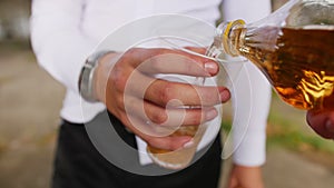 Pouring lemonade into a plastic glass from a bottle. Close up shot.