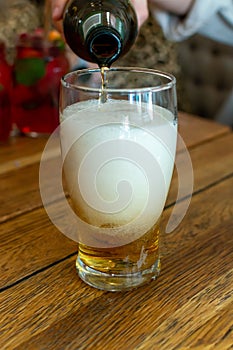 Pouring of light lager beer in glass