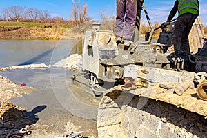 Pouring liquid concrete in bridge foundation