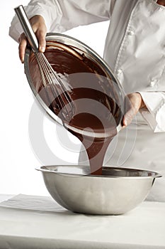 Pouring melted chocolate into a metal bowl