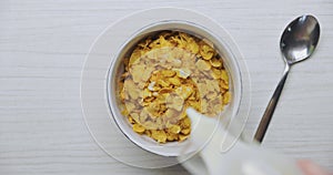 Pouring milk into bowl of cereals
