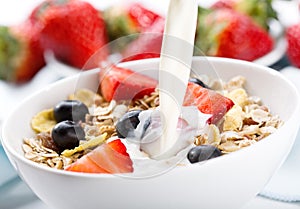 Pouring milk into bowl of cereals