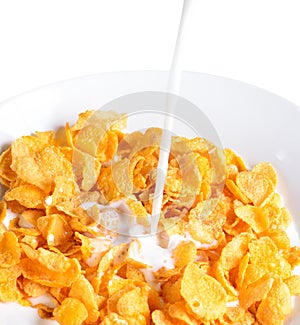 Pouring milk into bowl of corn flakes