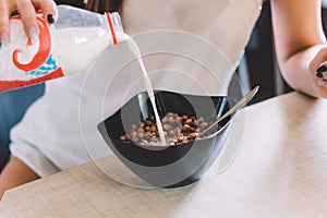 pouring milk in a cereal bowl
