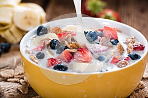 Pouring Milk on Cornflakes with fresh Fruits