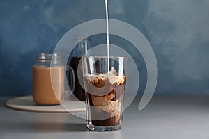 Pouring milk into glass with cold brew coffee