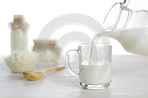 Pouring milk into the glass on dairy products background