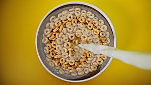 Pouring milk in honey cereals.